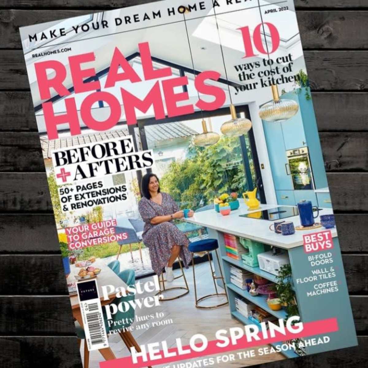 The cover of a home and lifestyle magazine titled "Real Homes" with an article on kitchen costs and a woman sitting at a kitchen island.