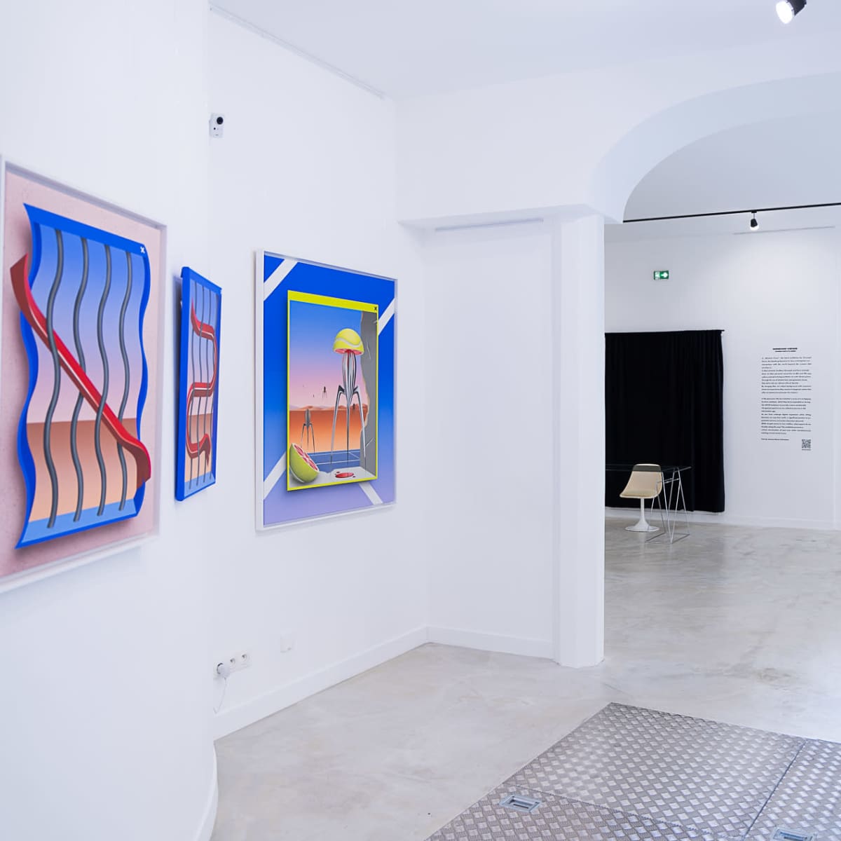 An art gallery interior featuring colorful abstract paintings on white walls, with a modern chair positioned near the entrance.