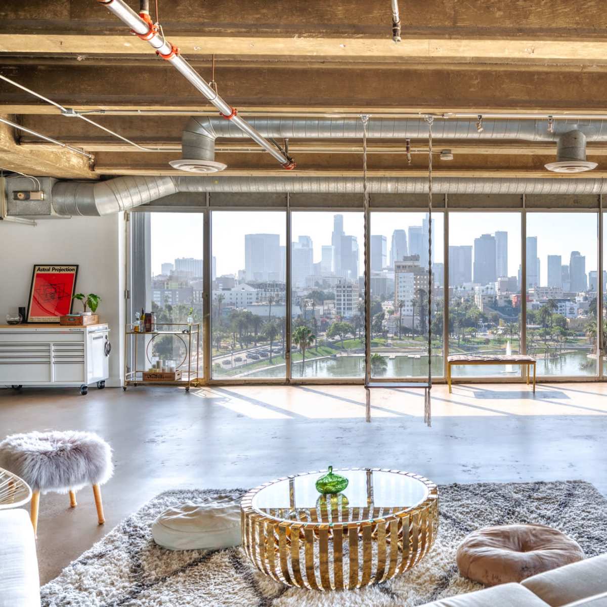 A modern urban living space with large windows offering a view of the city skyline.