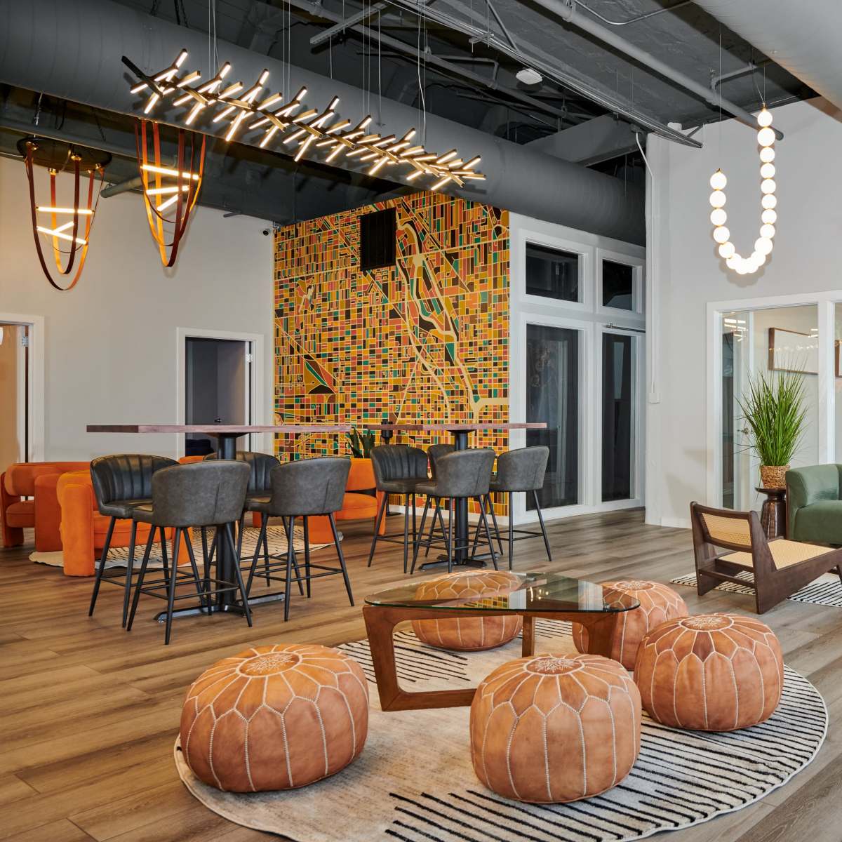 A modern lounge area with a mix of seating, decorative lighting, and vibrant wall art.