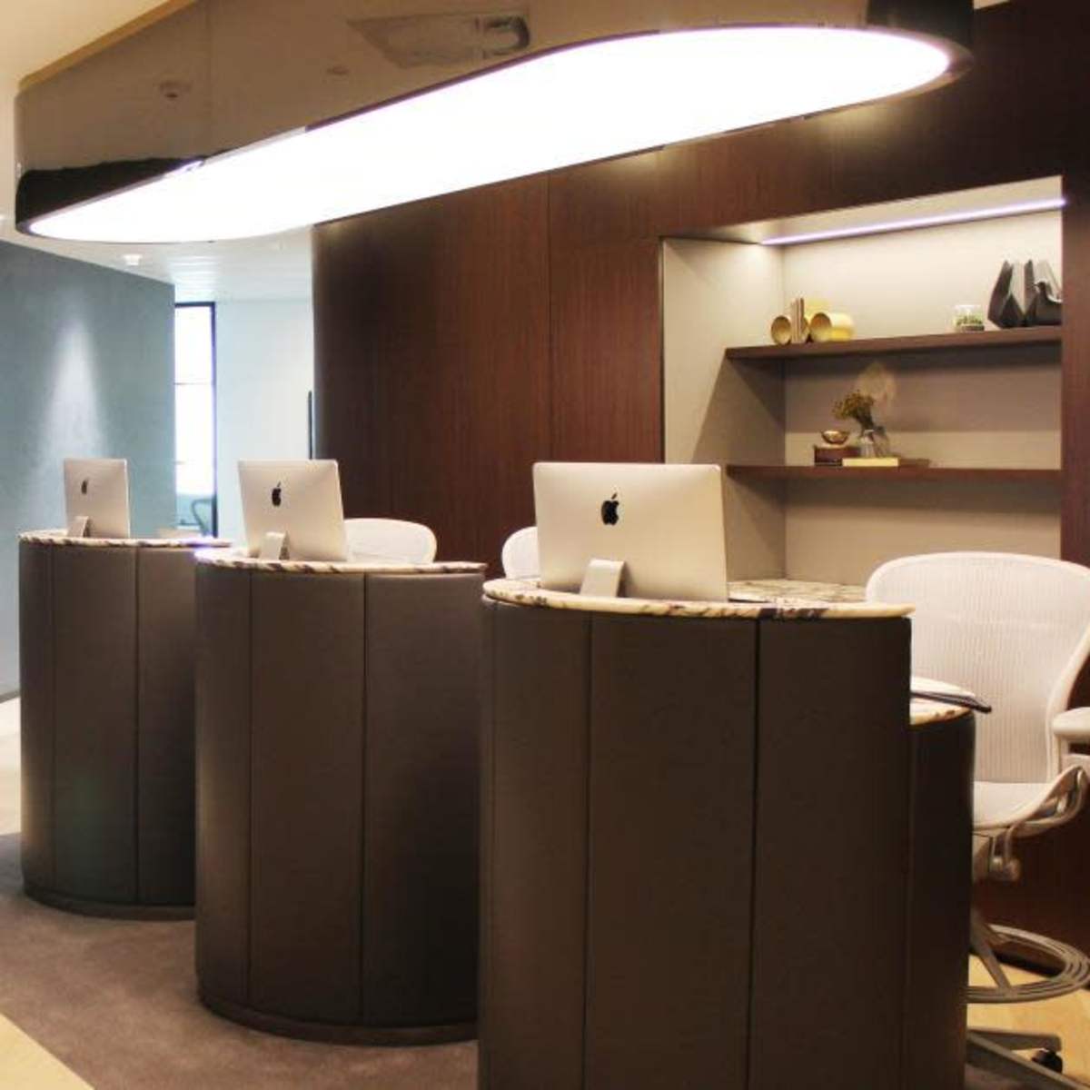 A modern reception area featuring two computer stations and abstract artwork on the walls.