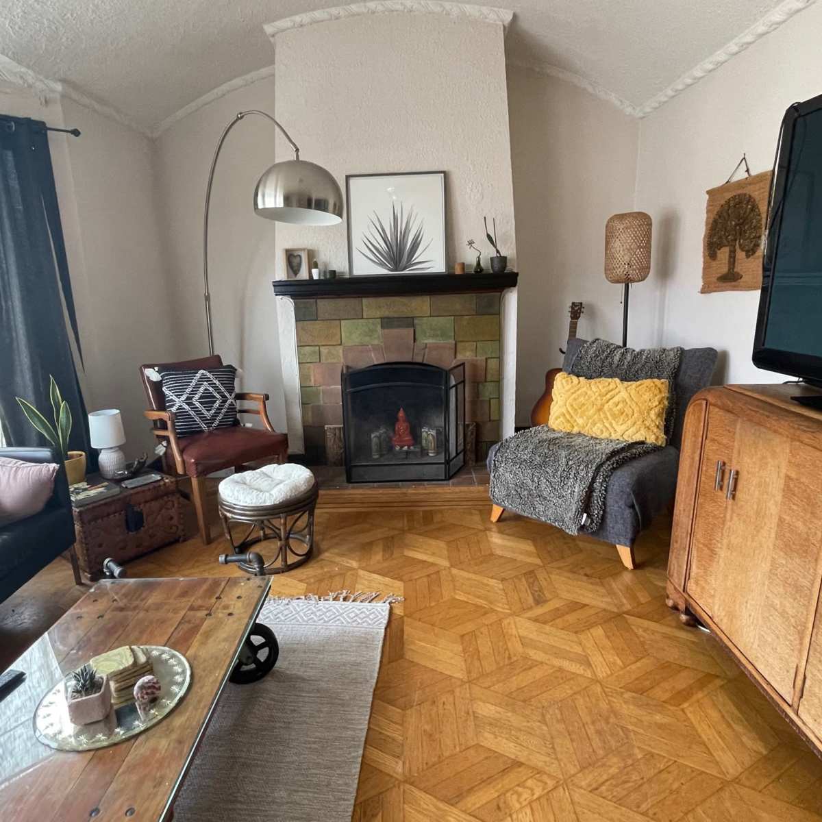 A cozy living room featuring a fireplace, a wooden coffee table, a television, and a mix of comfortable seating arrangements.