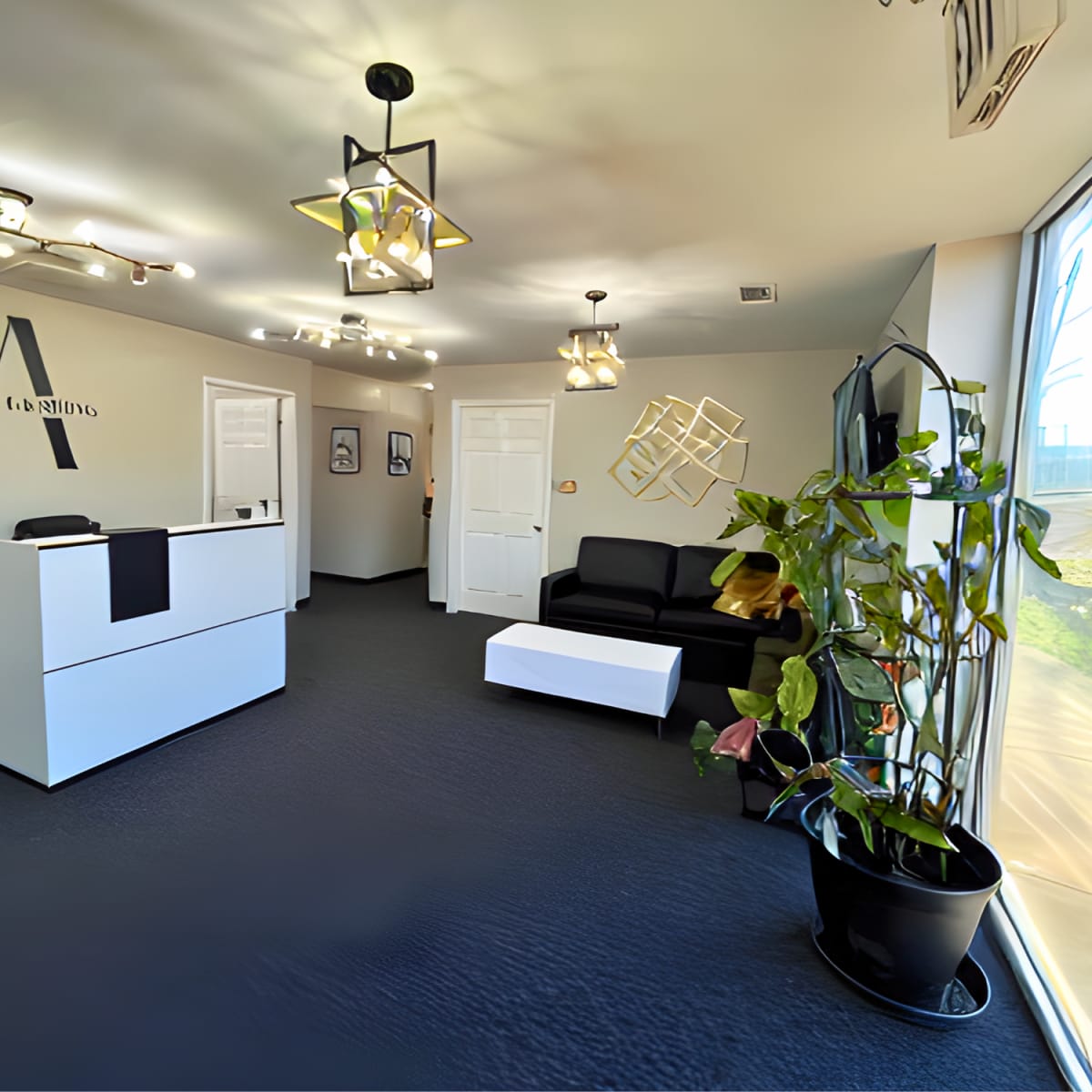A modern reception area with a white desk, a black sofa, a coffee table, and decorative lighting.