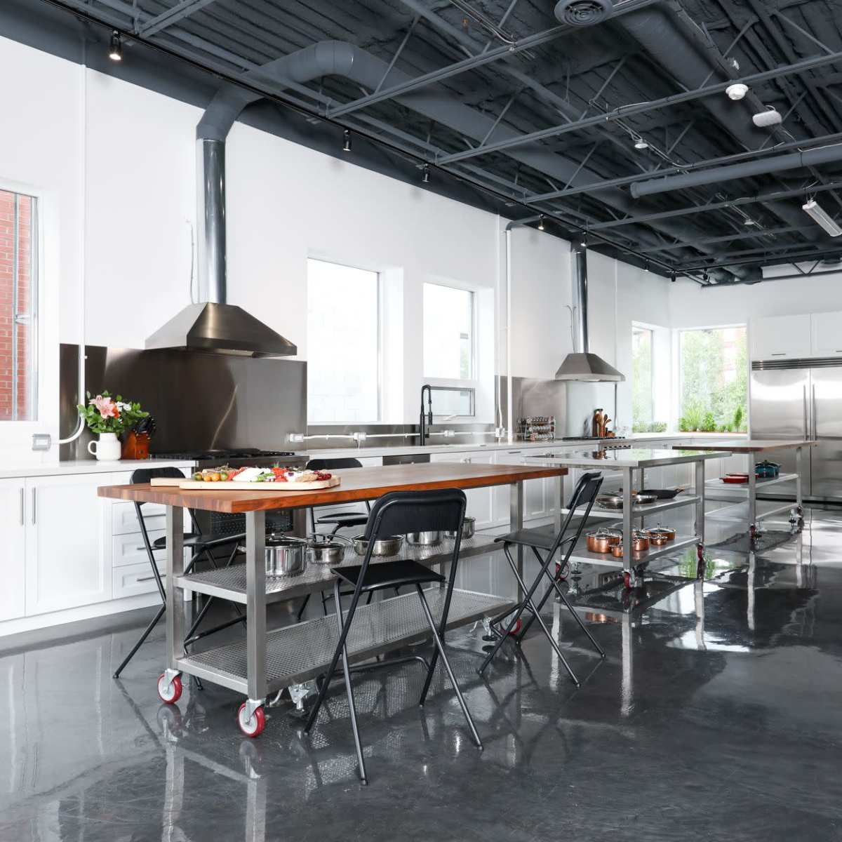 A modern kitchen with stainless steel appliances, a large central island, and multiple windows letting in natural light.