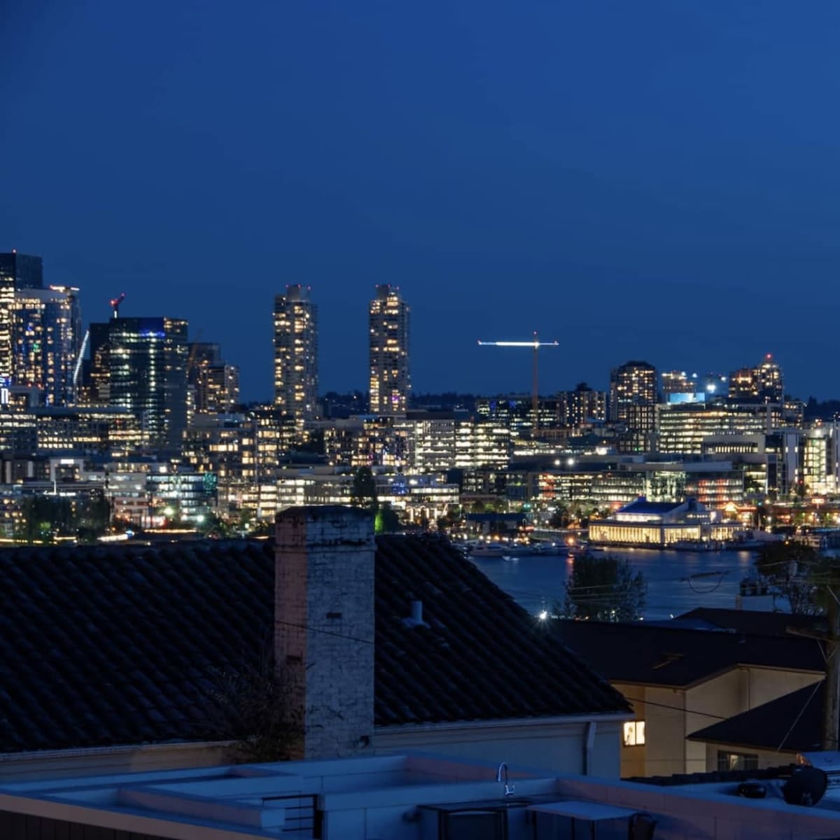 A nighttime view of Seattle's skyline, featuring the Space Needle illuminated among the city lights and the waterfront.