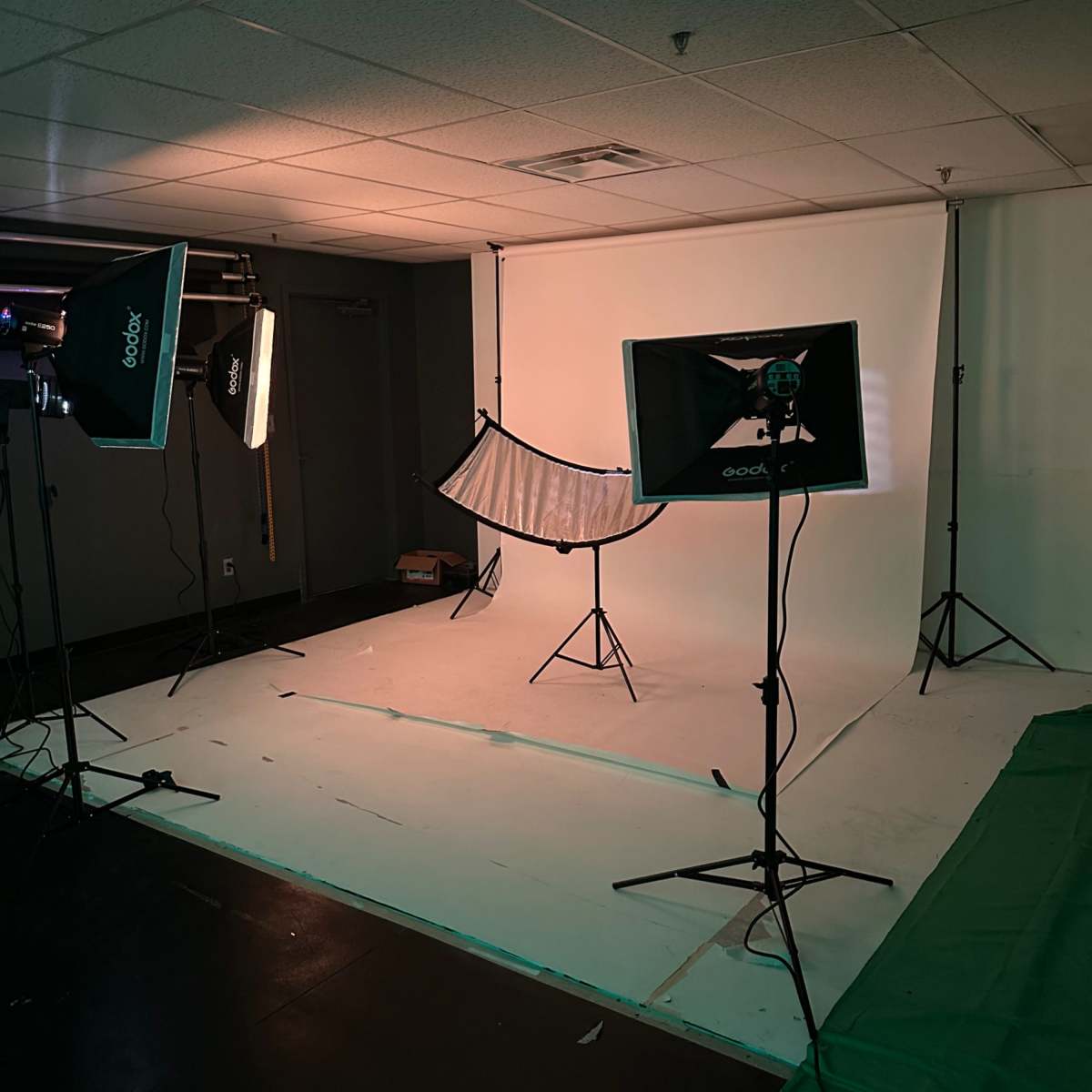 A photography studio setup with softboxes, a backdrop, and equipment arranged for a photo session.