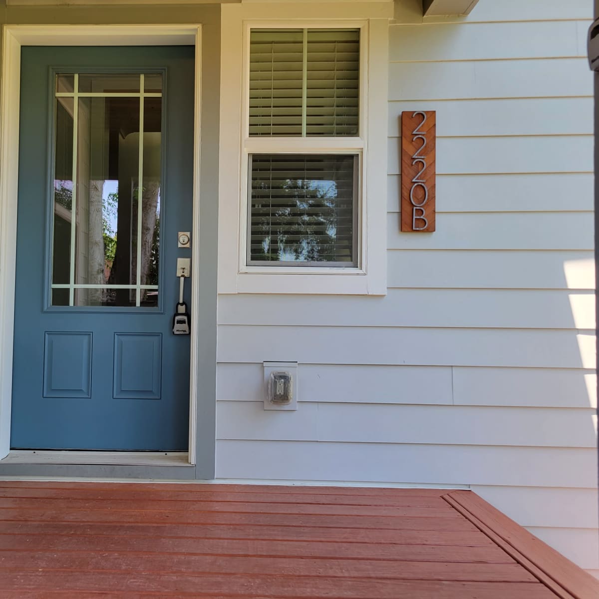 A front entrance with a blue door and the house number 2220B displayed on the exterior wall.