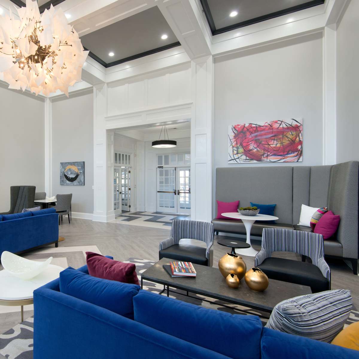 A spacious, modern living area features a fireplace, contemporary seating arrangements, and colorful artwork on the walls.