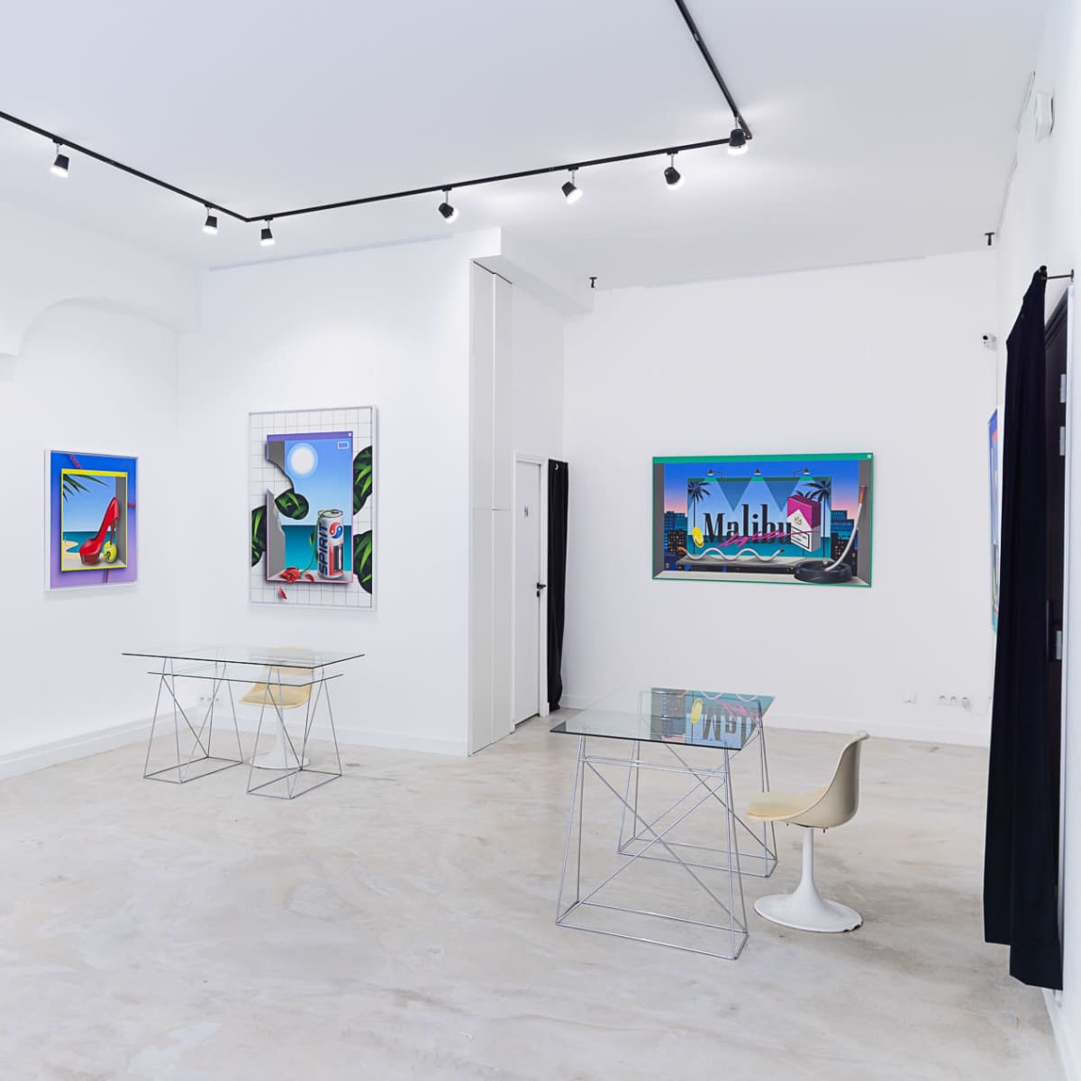 A modern art gallery with white walls, featuring colorful artwork and minimalistic furniture.