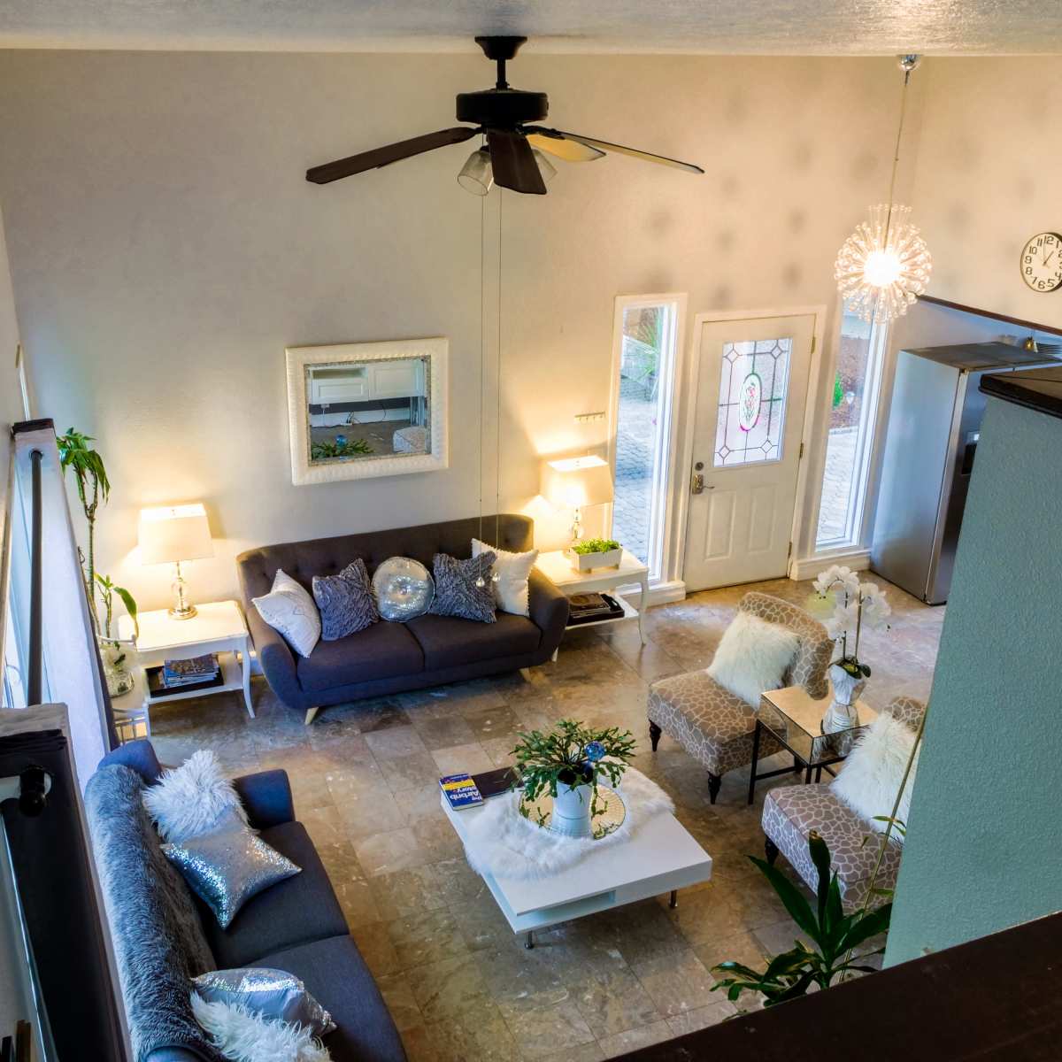 A modern living room with two sofas, a coffee table, and a front door leading to an outdoor area.