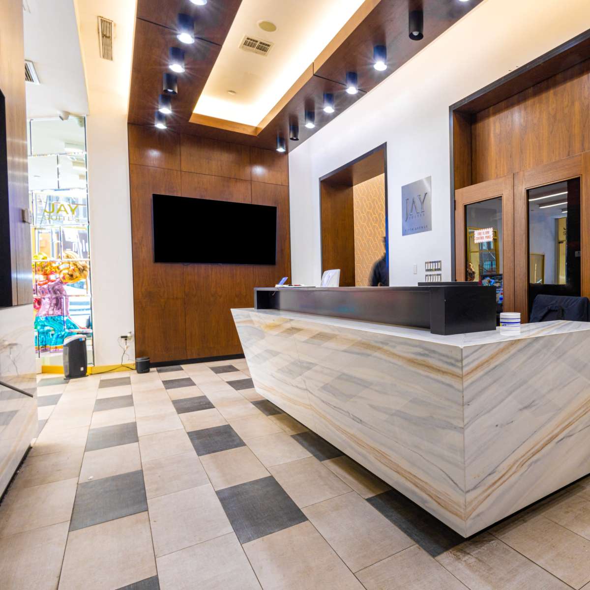 A modern reception area featuring a marble front desk and a sign directing to the "Monroe Room."