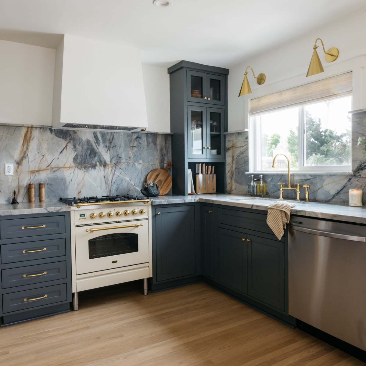 The kitchen features dark blue cabinetry, a marble backsplash, a white stove, and hardwood flooring.