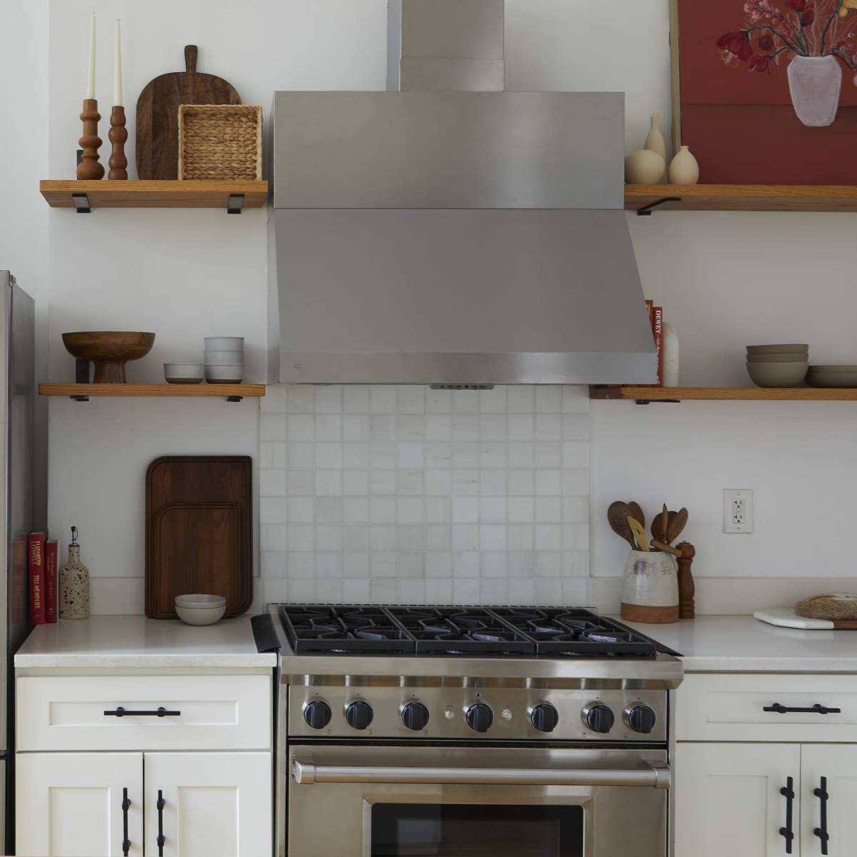 A modern kitchen features stainless steel appliances, including a refrigerator and a range, with open shelving displaying various kitchenware.