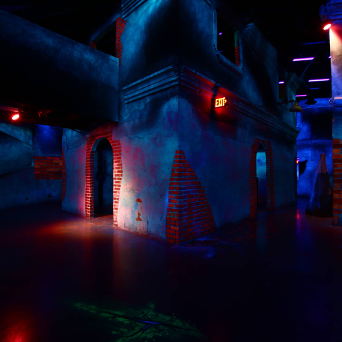 A dimly lit, colorful maze-like interior with brick walls and various doorways.