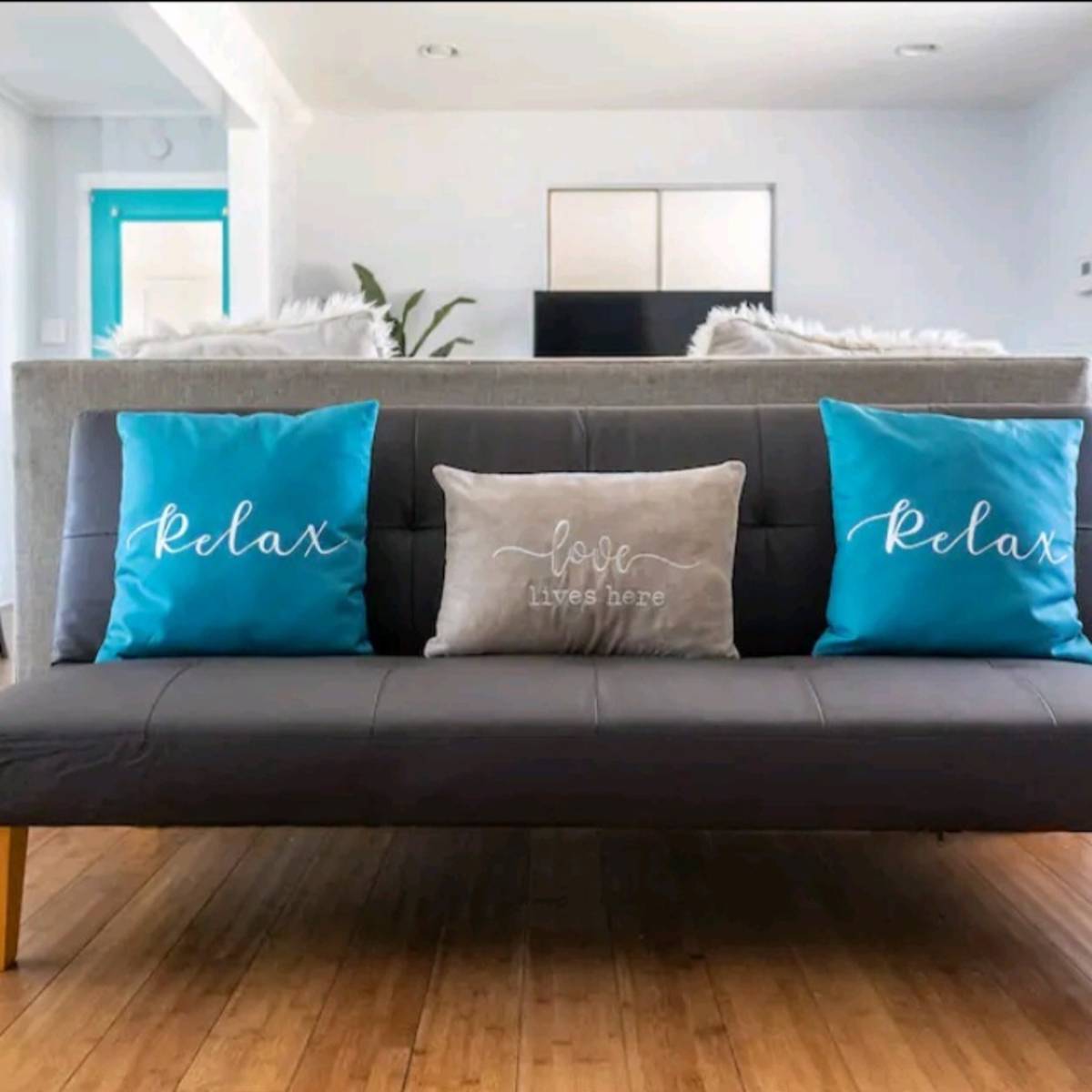 A gray sofa with blue and gray decorative pillows in a bright, airy living space.