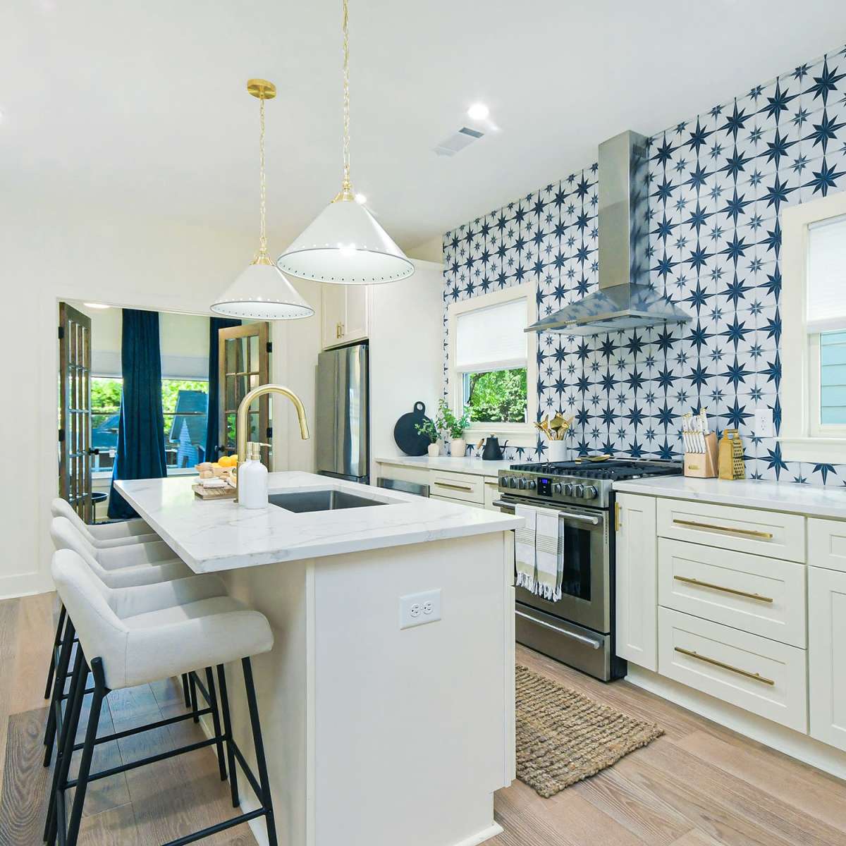 The kitchen features a marble countertop island with three stools, complemented by a patterned wallpaper and modern appliances.