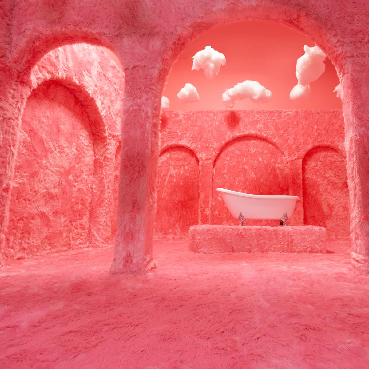 A room with pink, fluffy walls and arches, featuring a white bathtub at its center.