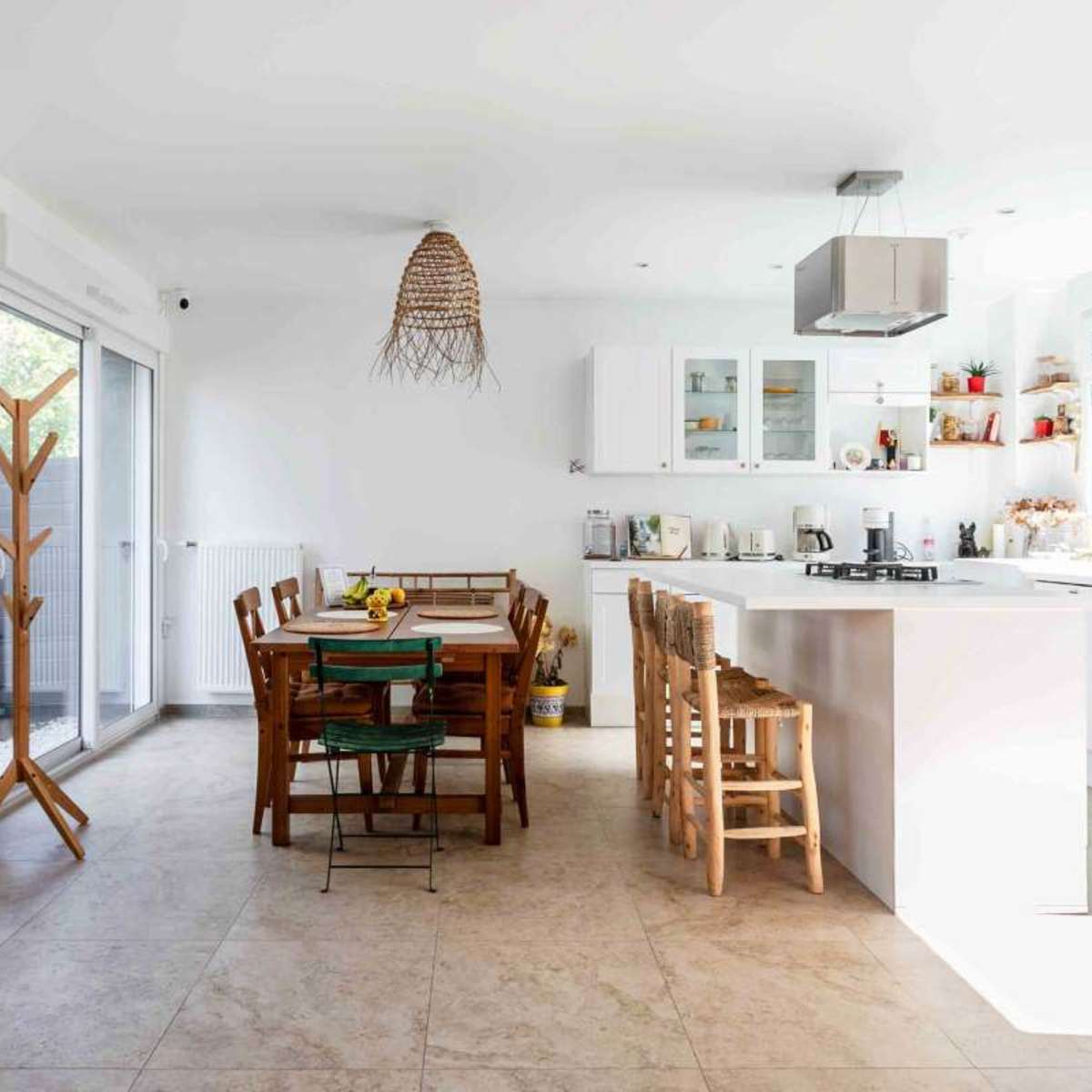 A modern kitchen and dining area feature a light-colored tile floor, wooden dining furniture, and a retro blue refrigerator.
