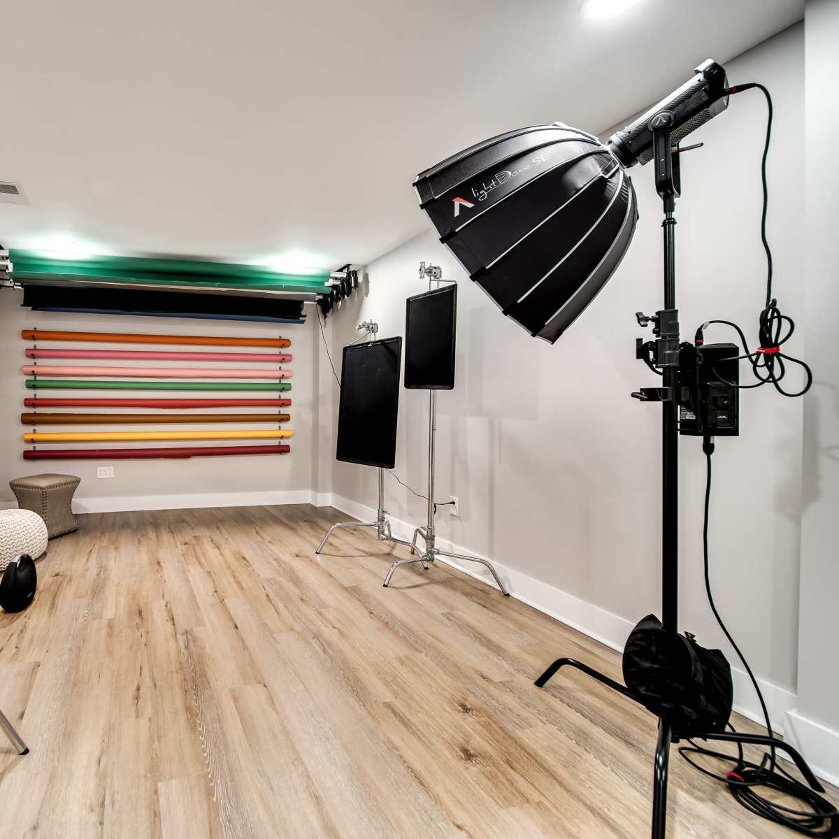 A photography studio with backdrops, lighting equipment, and props arranged on a wooden floor.