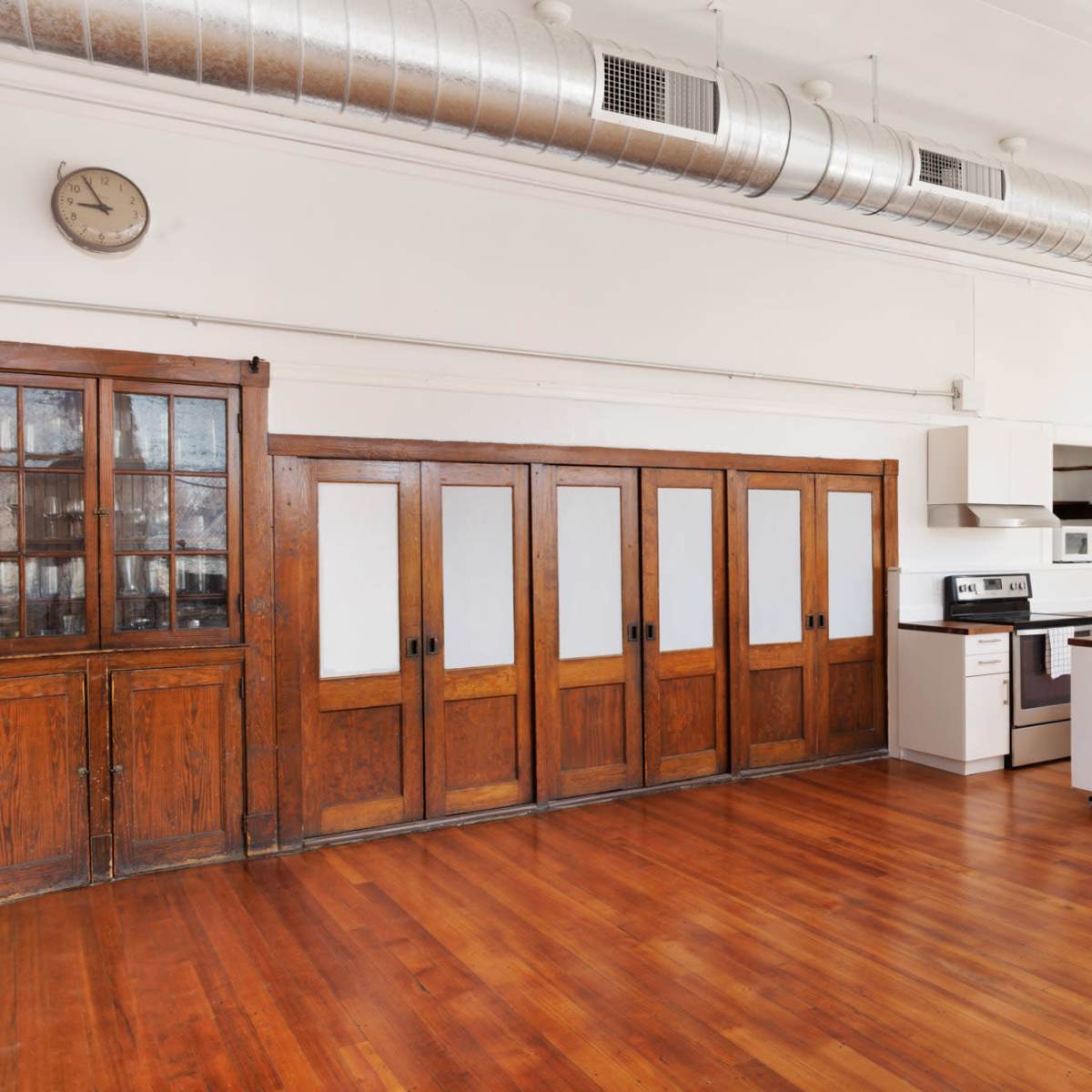 A spacious kitchen with wooden cabinets, modern appliances, and large windows allowing natural light.
