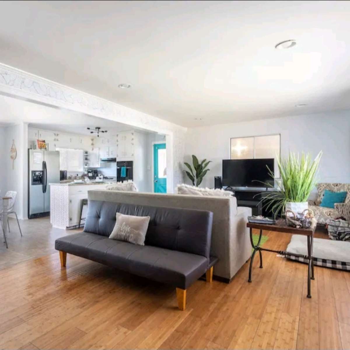 A partially open living space featuring a seating area with a sofa, a coffee table, and a dining area with a table and chairs.