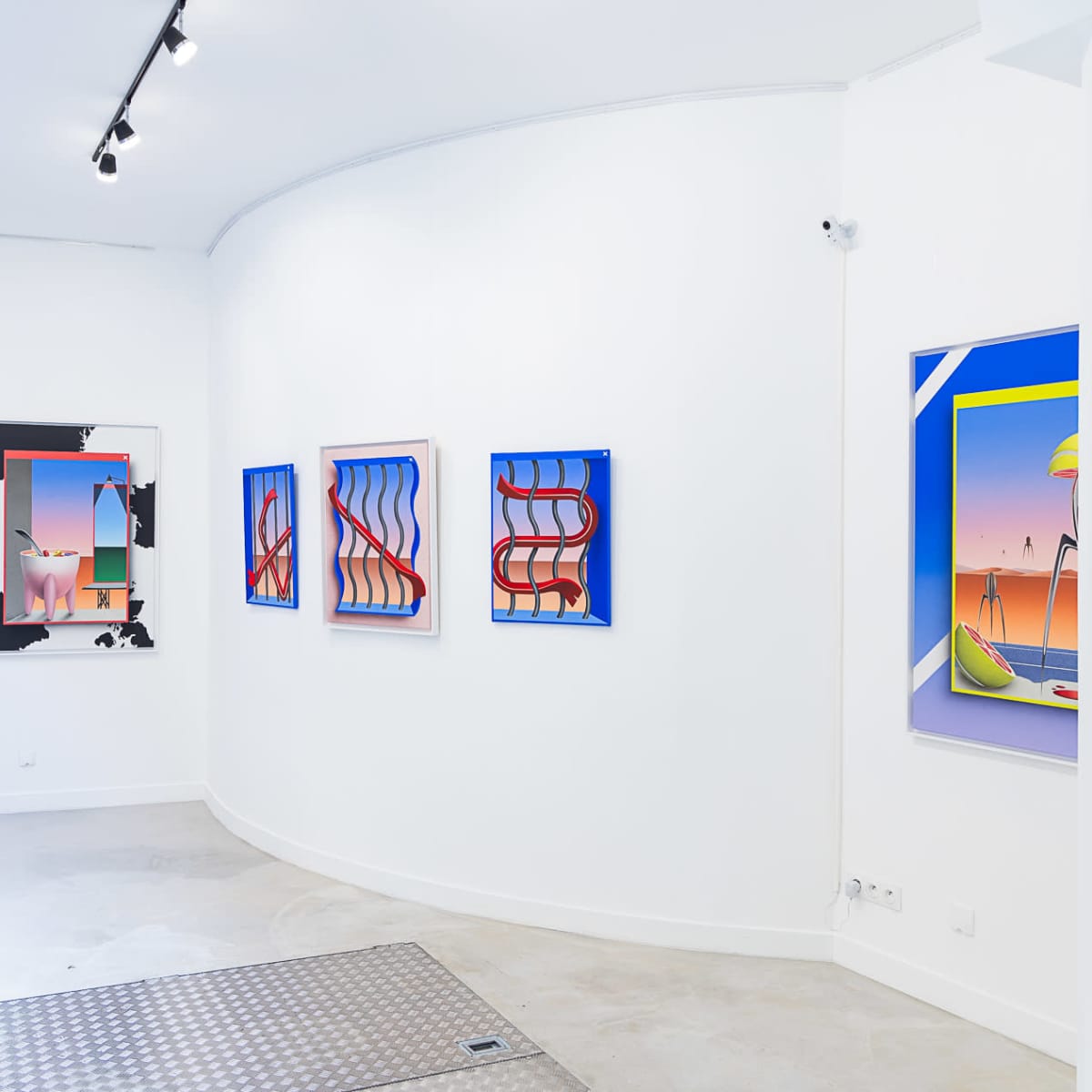 An art gallery with several colorful framed paintings on white walls, featuring a curved layout and a mix of modern design elements.