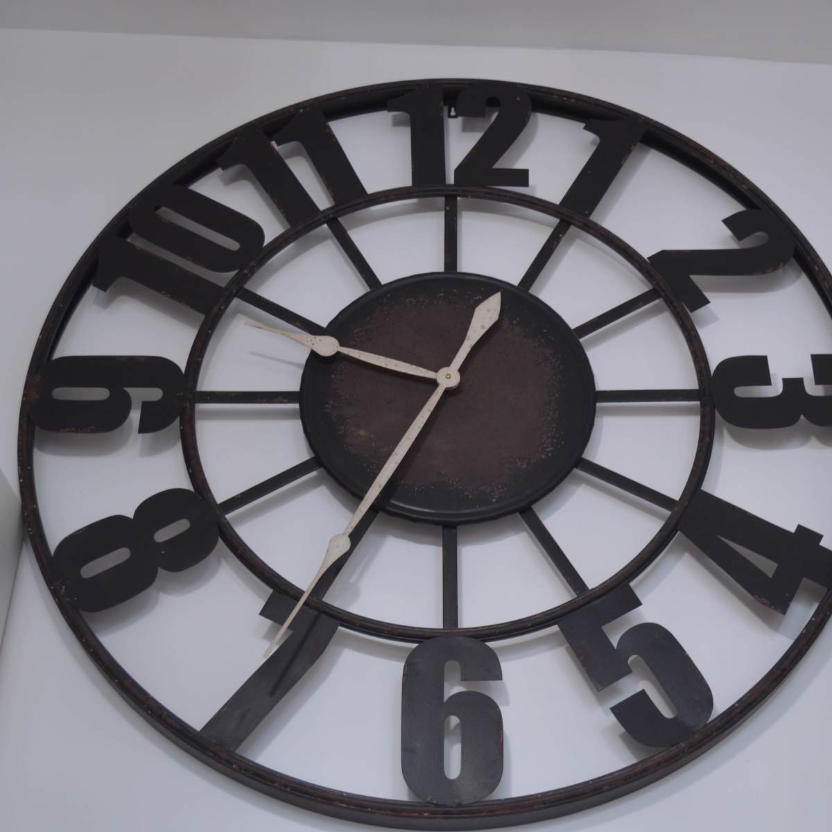 A large, round wall clock with bold black numbers and minimalistic hour and minute hands.
