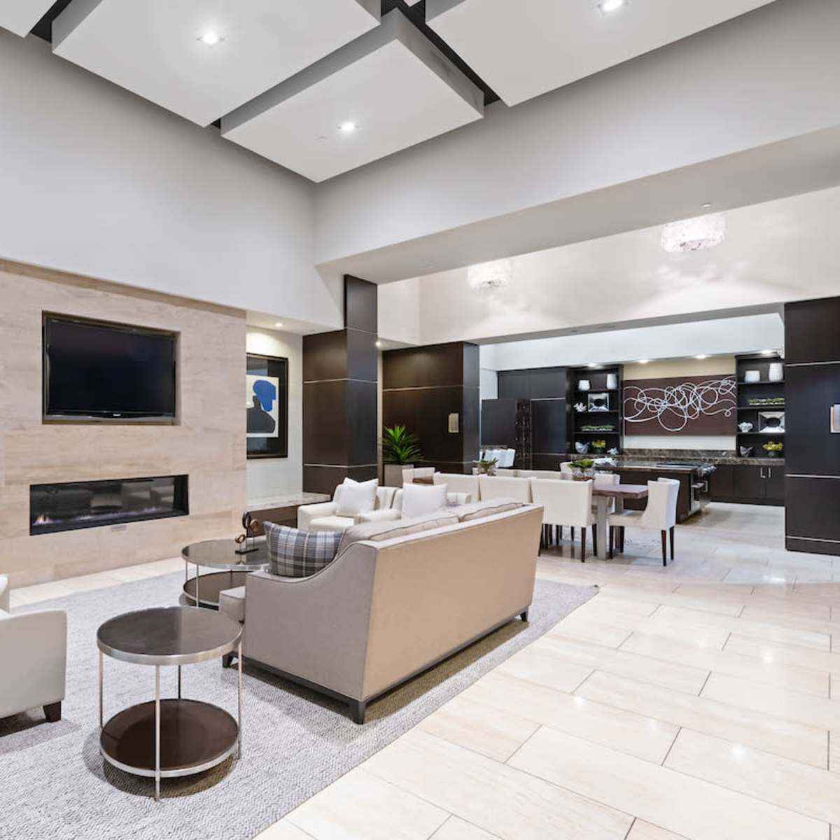A modern lounge area with a fireplace, seating arrangements, and dining space in the background.