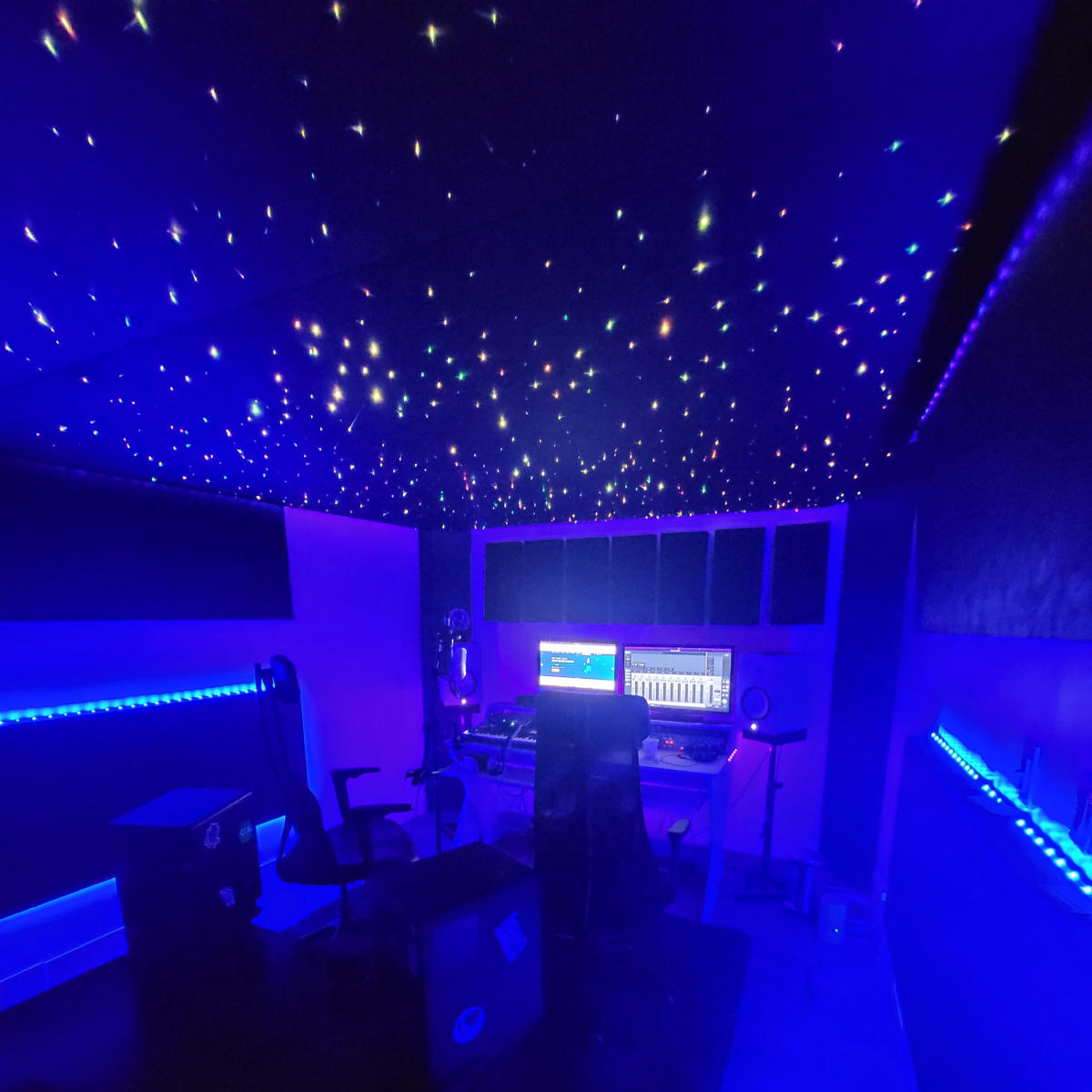 A music production studio with a starry ceiling and blue LED lighting.