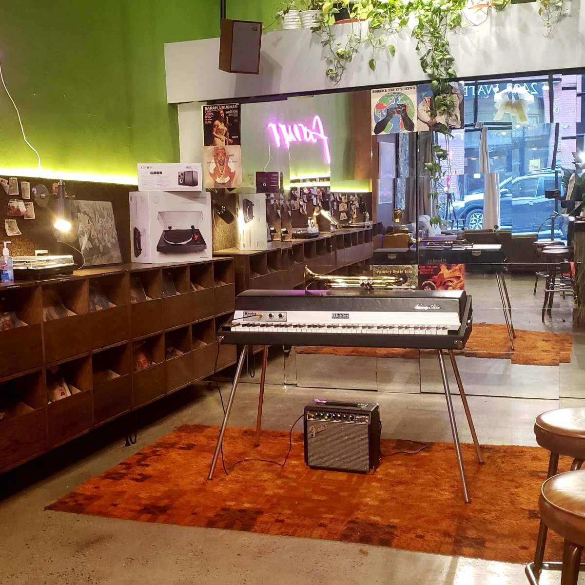 A vibrant music shop with a retro keyboard set on a wooden stand, surrounded by shelves filled with records and decorated with photos along the walls.