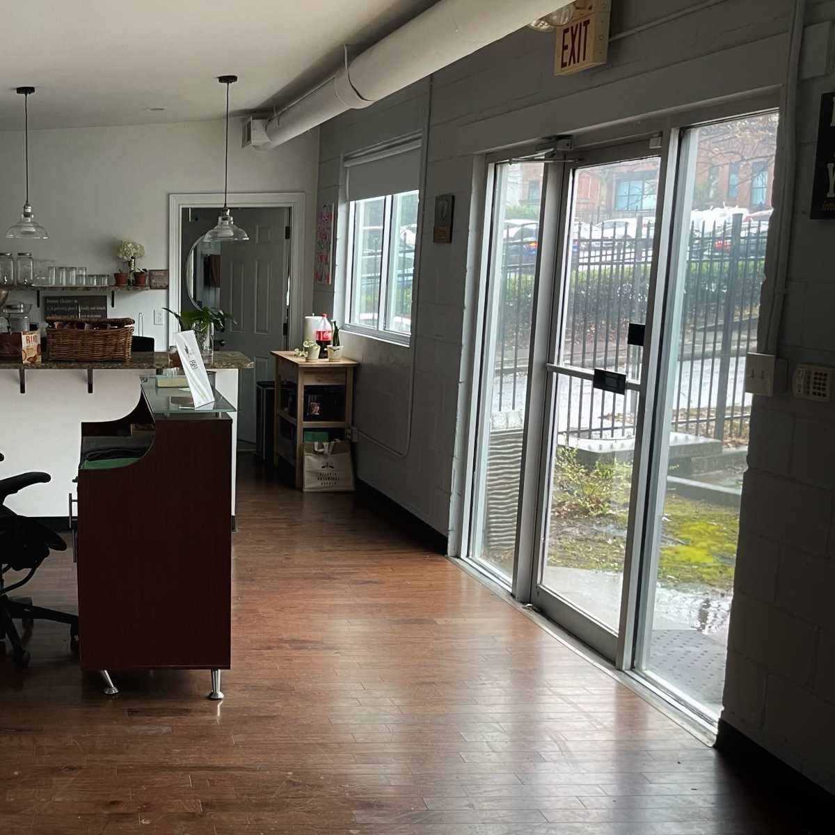 A bright, spacious office area with a desk, chairs, and a photography umbrella setup.