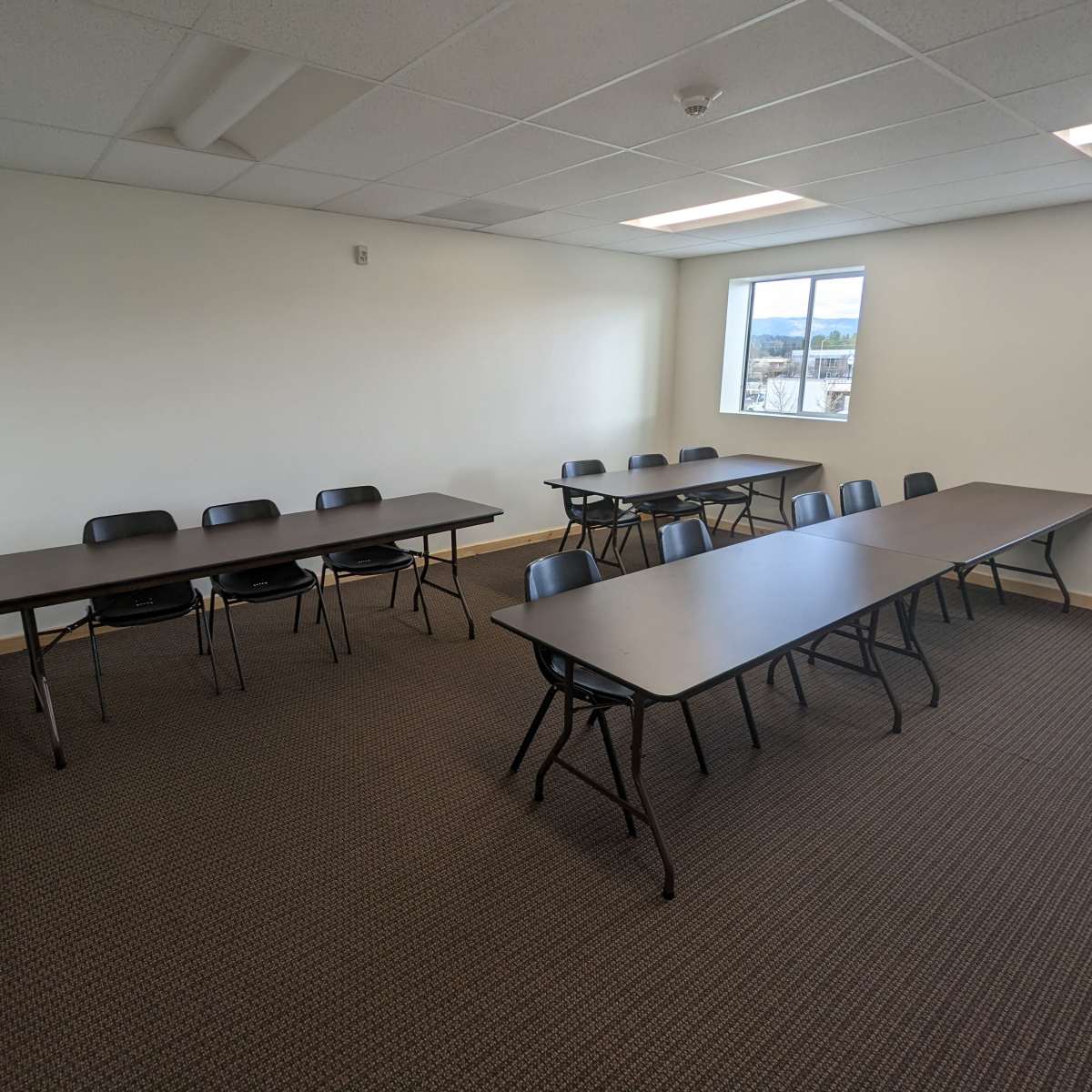 A classroom with two rows of tables and chairs arranged in a functional layout.