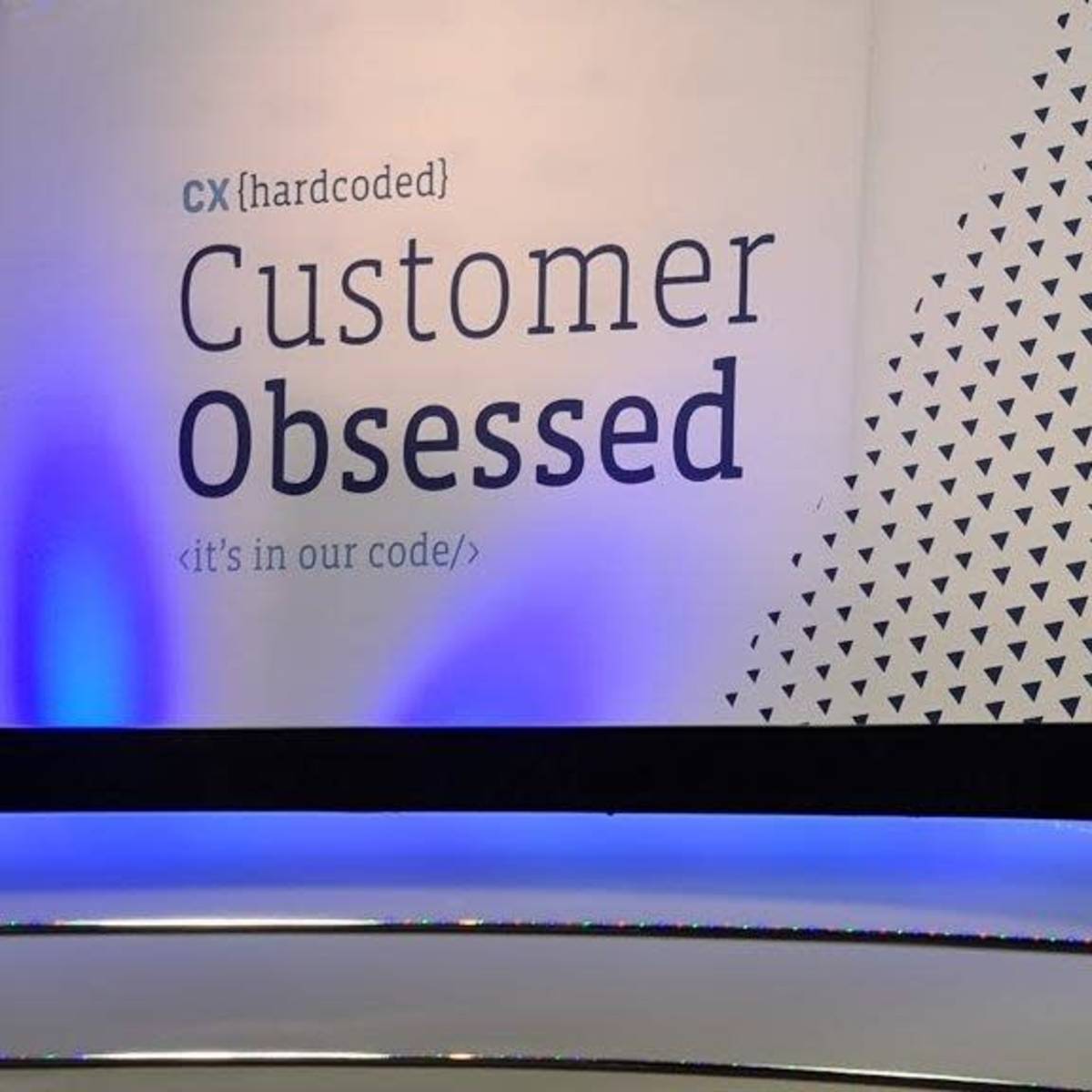 A conference stage backdrop with the text "Customer Obsessed" alongside the logo of CyberCX.