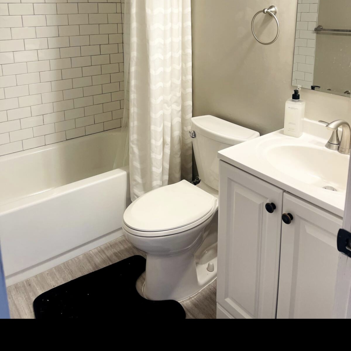 A bathroom featuring a bathtub with a shower curtain, a toilet, and a vanity with a mirror.