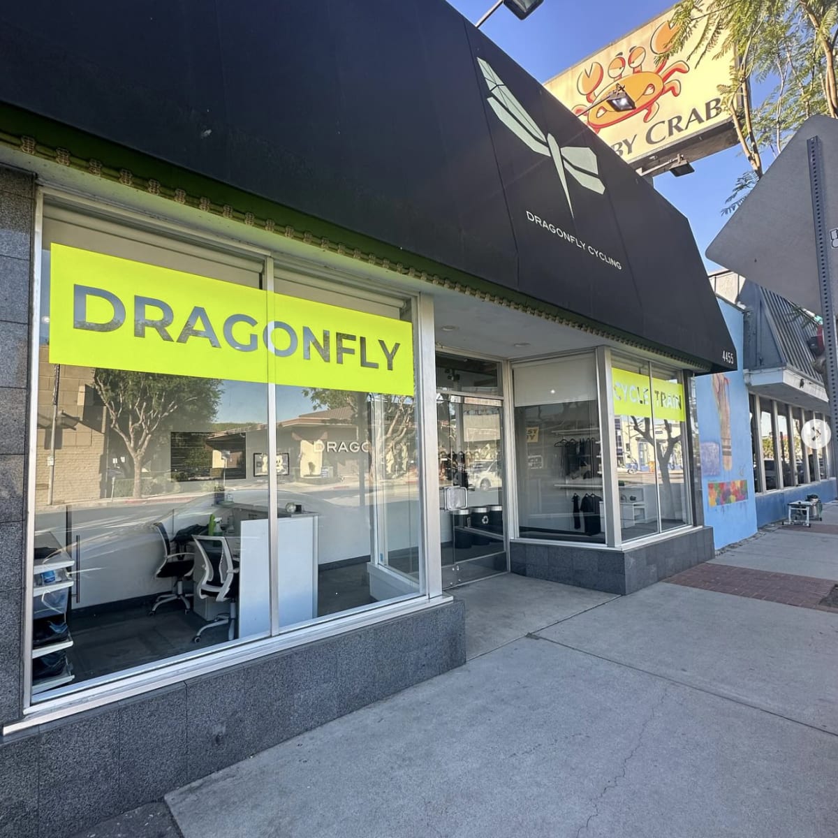 The storefront features a large, bright yellow sign reading "DRAGONFLY" above a glass entryway.