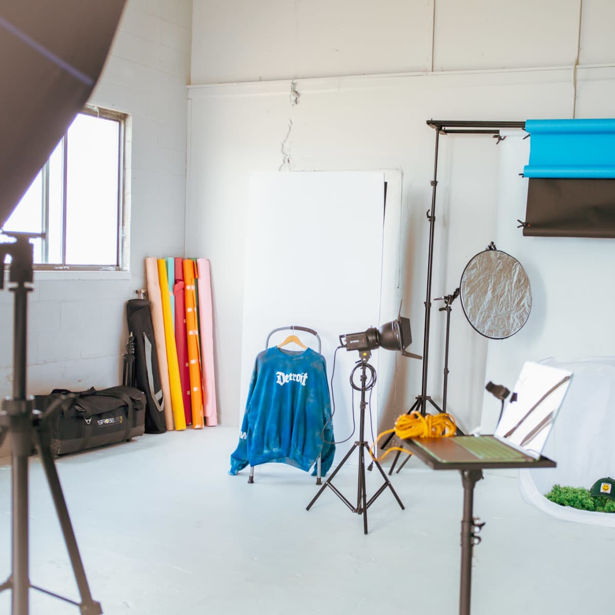 A photography studio with lighting equipment, backdrops, and props arranged in a bright, open space.