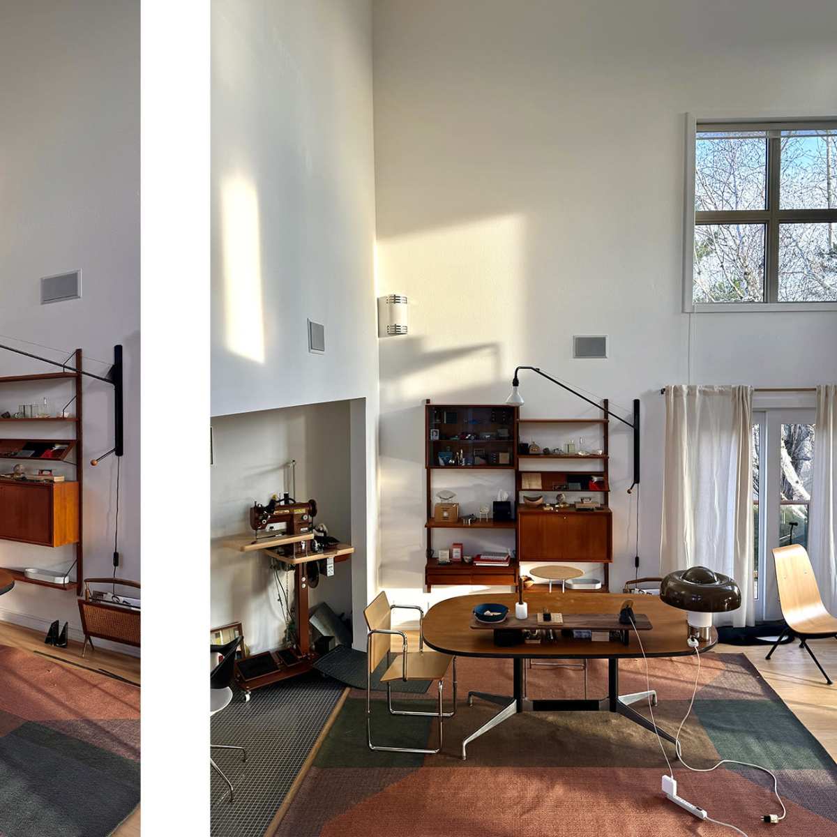 A modern workspace with two distinct areas, featuring wooden furniture, shelves displaying various items, and ample natural light streaming through large windows.