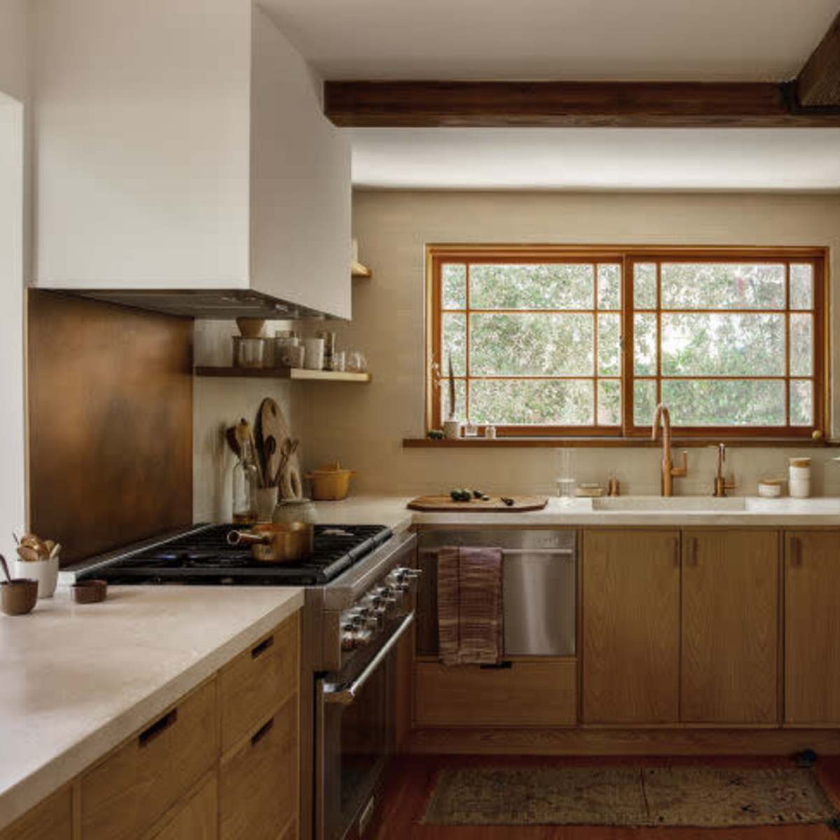 The kitchen features wooden cabinetry, a large sink, and a window that brings in natural light.