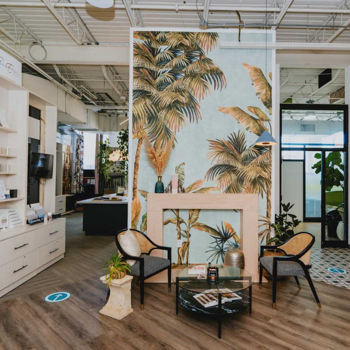 A modern interior space featuring a tropical-themed wall mural, two chairs, a glass table, and well-organized display areas.
