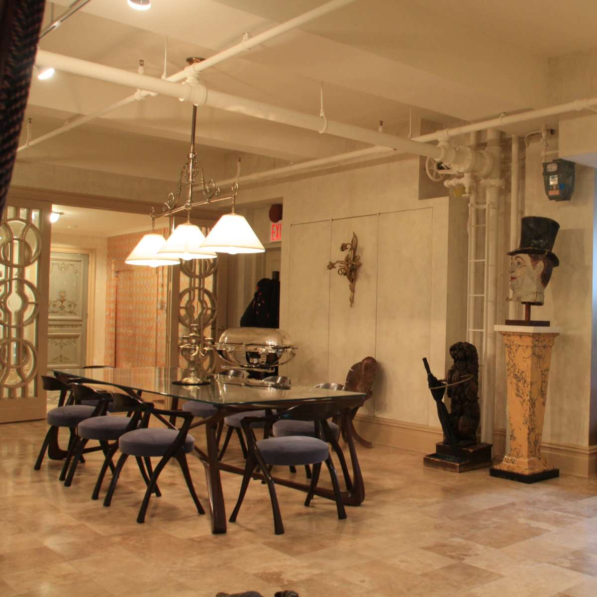 A spacious room with a dining table, decorative items, and a partially visible bedroom area in the background.