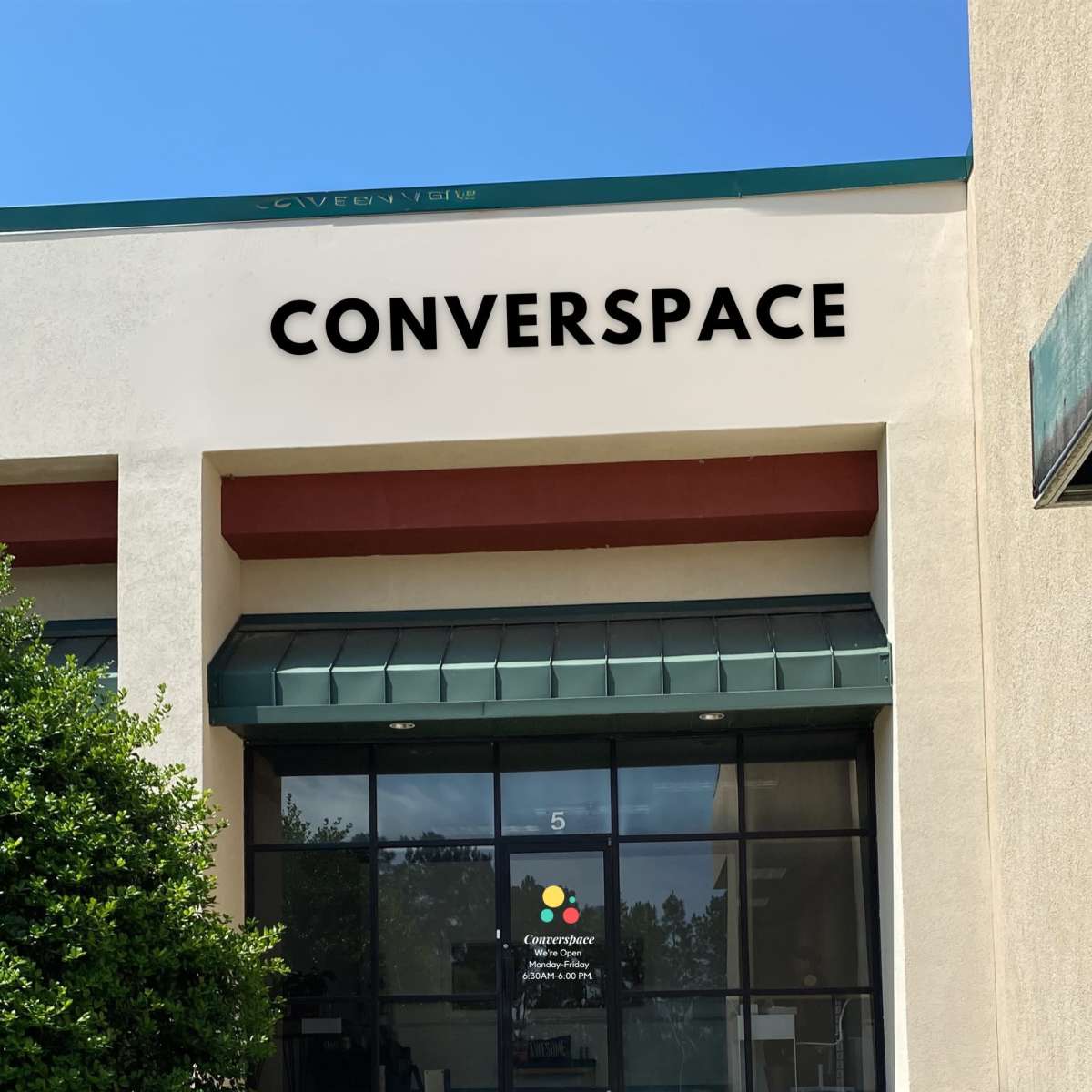 A business front with the sign "CONVERSPACE" above the entrance and a colorful logo in the window.