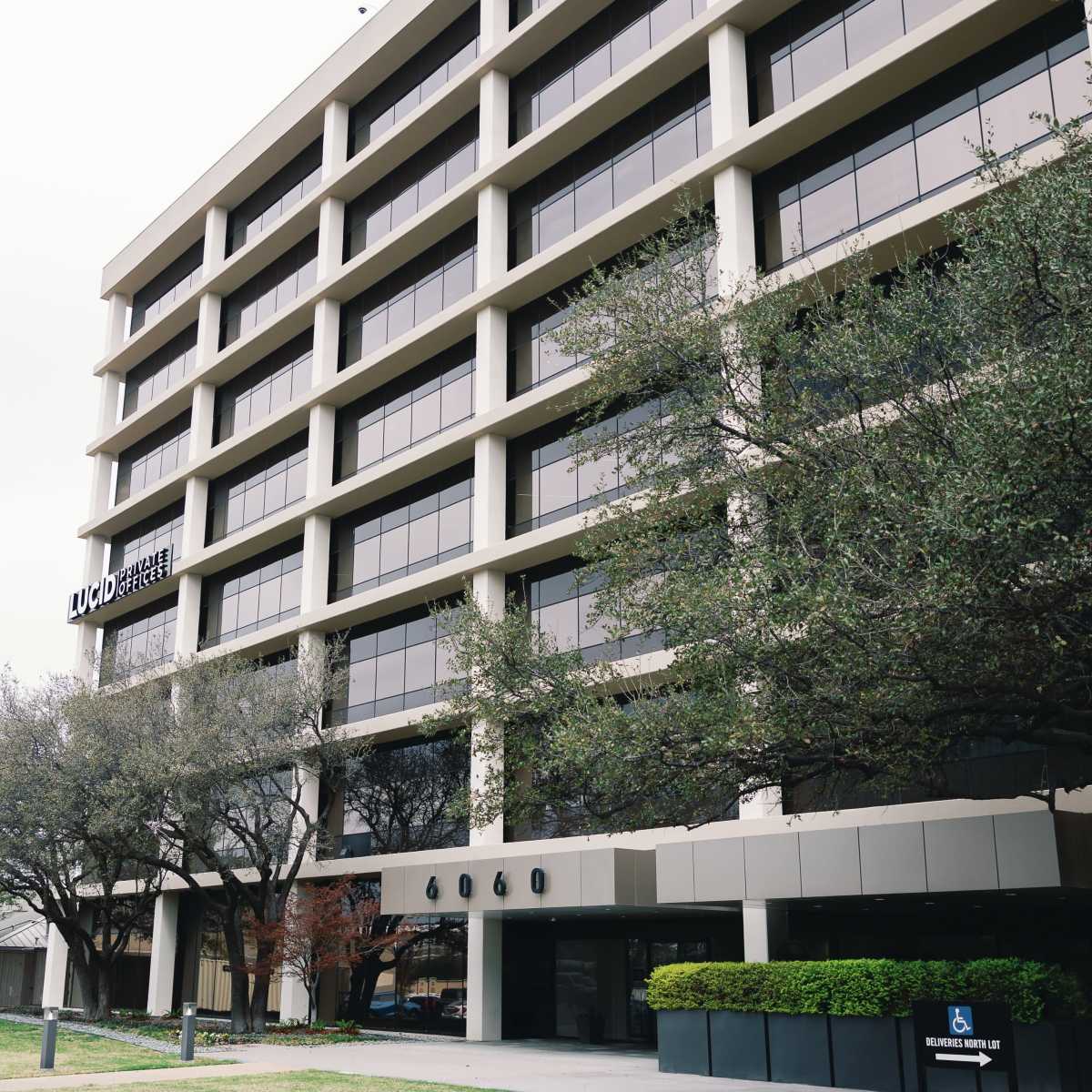 A multi-story building featuring large windows and surrounded by trees, with signage indicating "UMD Cancer Center."