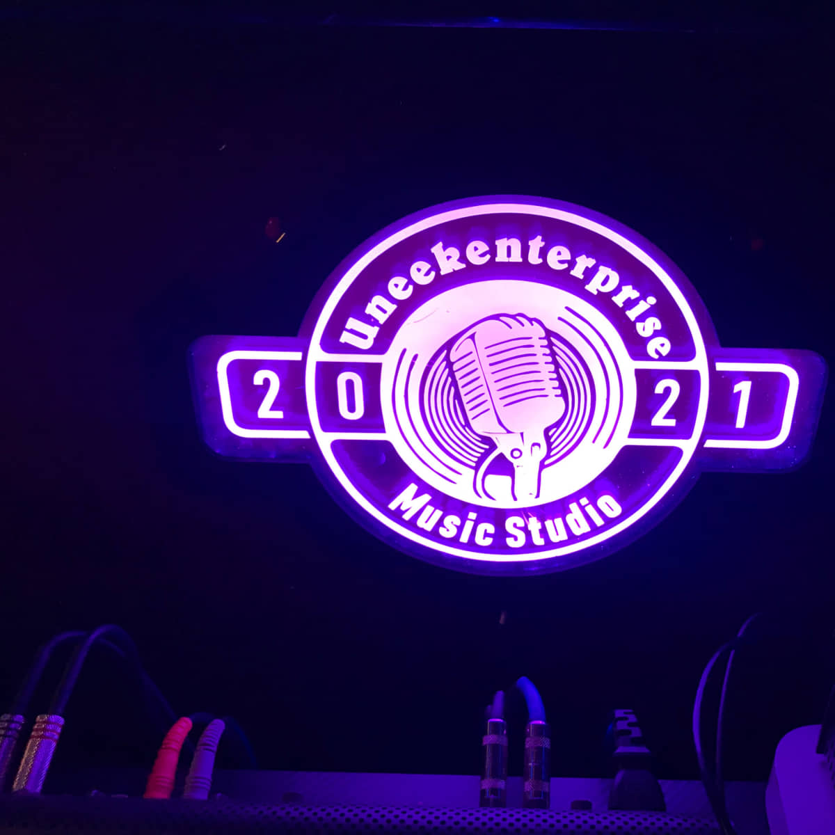 A neon-lit circular logo for "Uneekenterprise Music Studio," with the year "2021" prominently displayed.