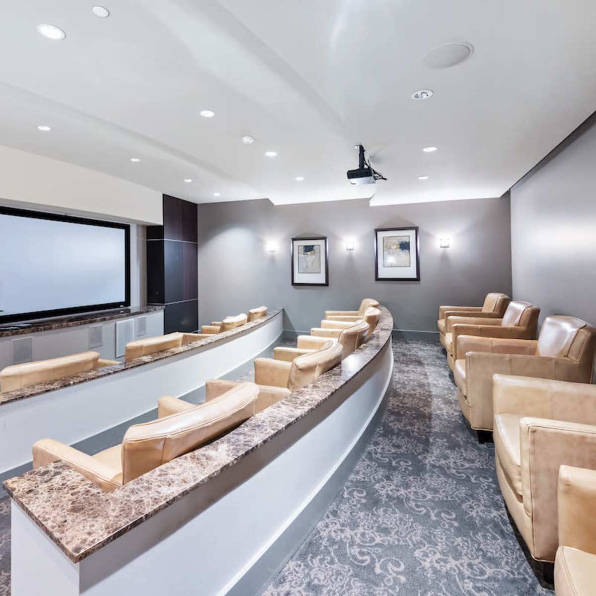 A sleek, modern conference room with curved seating, a large screen, and a neutral color palette.