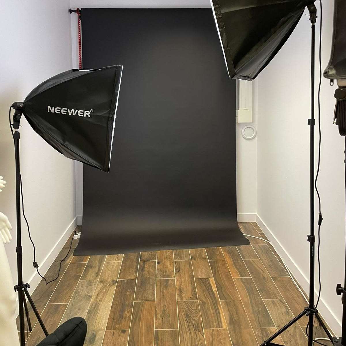 A photography studio featuring two large softbox lights positioned on either side of a black backdrop.