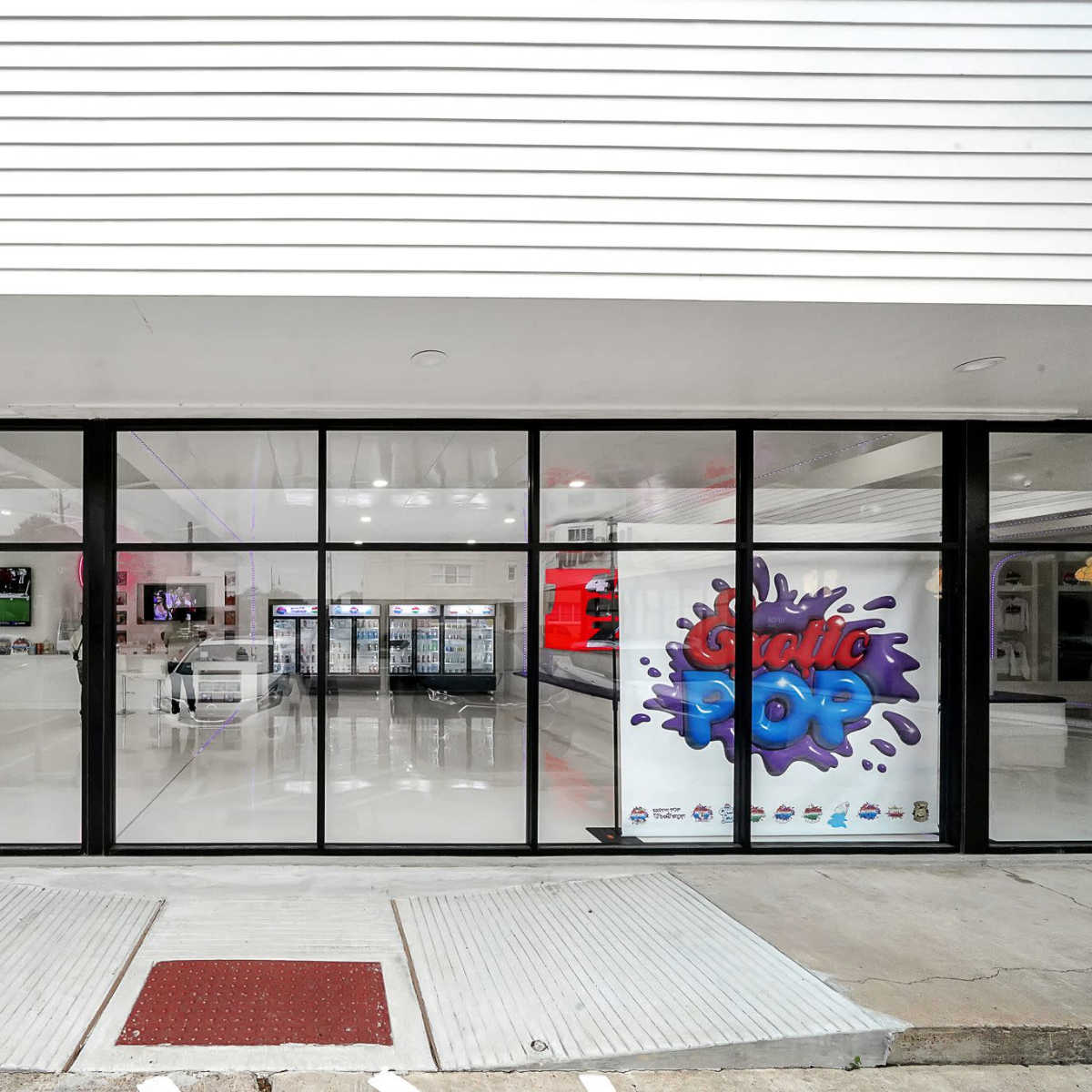 A modern retail store with large glass windows and a colorful sign that reads "Exotic Pop" on the front wall.