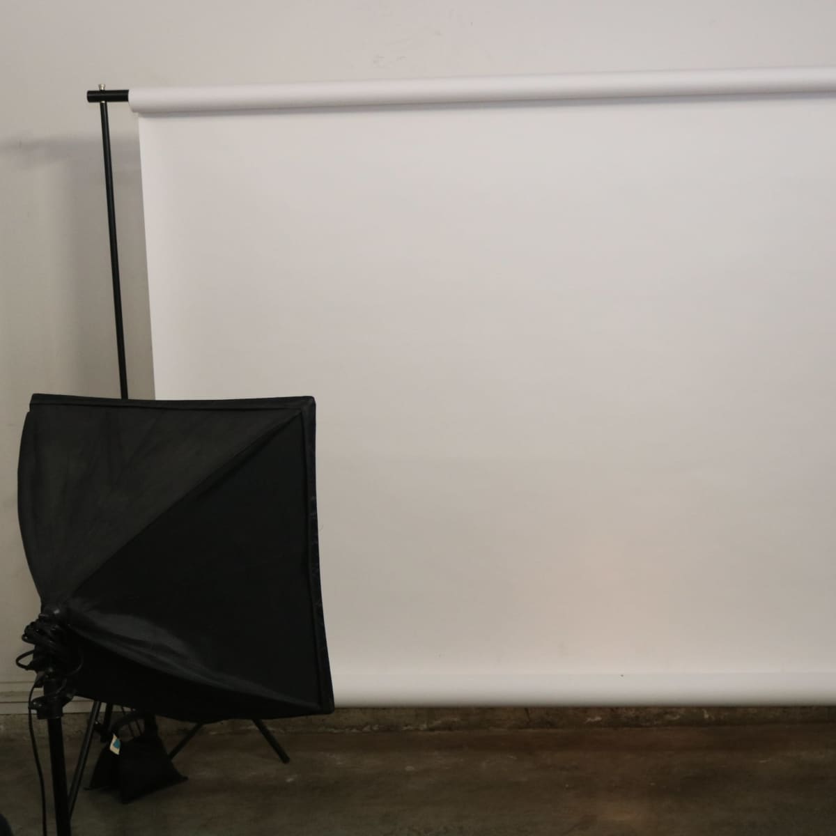 A blank white backdrop with two black softbox lighting setups on either side.