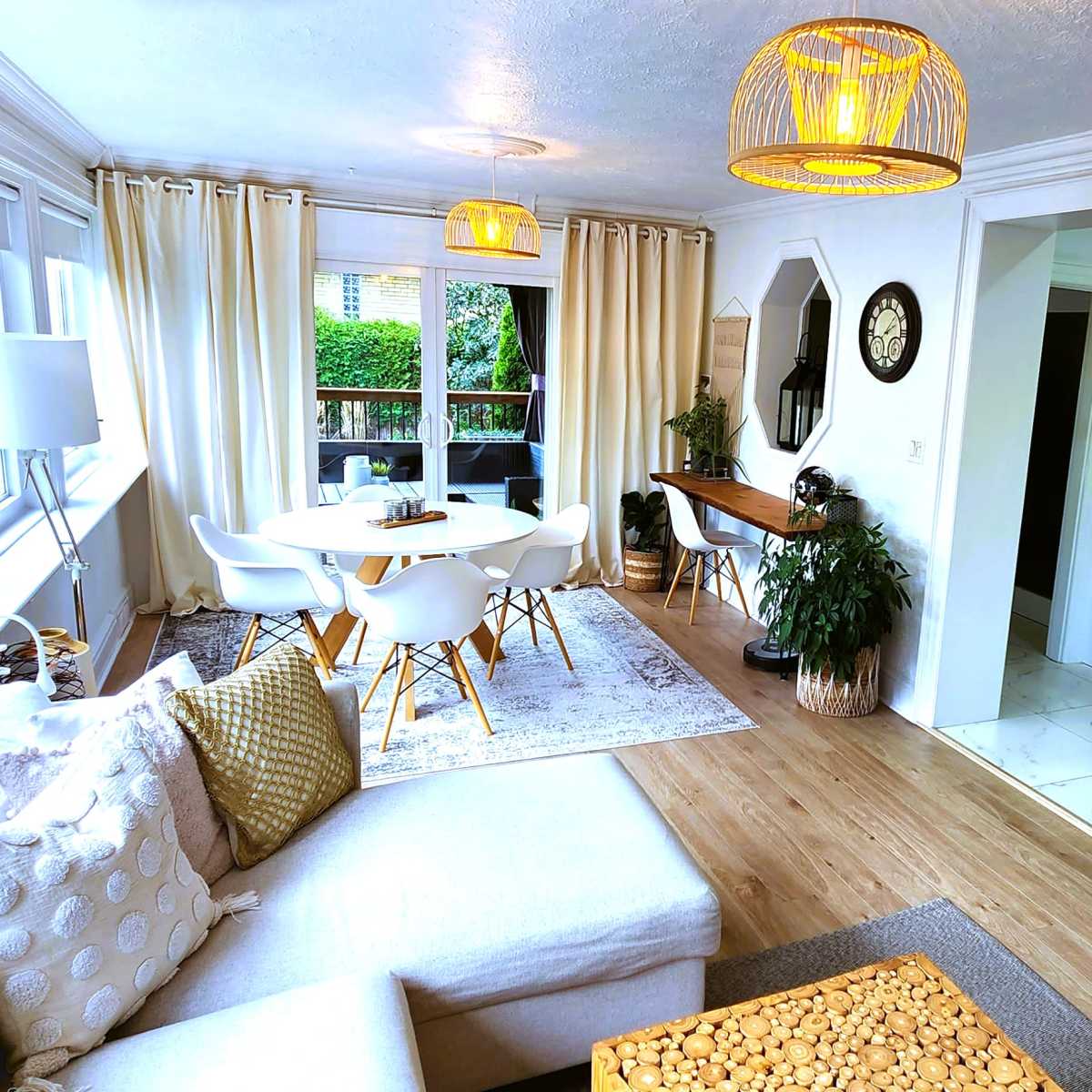 A bright, open-concept living and dining area featuring a modern kitchen, a cozy seating area, and a dining table surrounded by chairs.