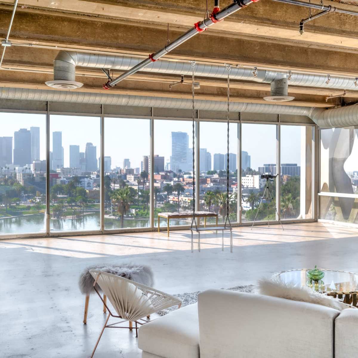 A modern, open interior space with large windows overlooking a city skyline and a body of water.