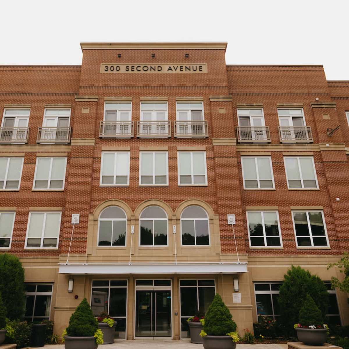 A four-story brick building with the address "300 SECOND AVENUE" prominently displayed on the facade.
